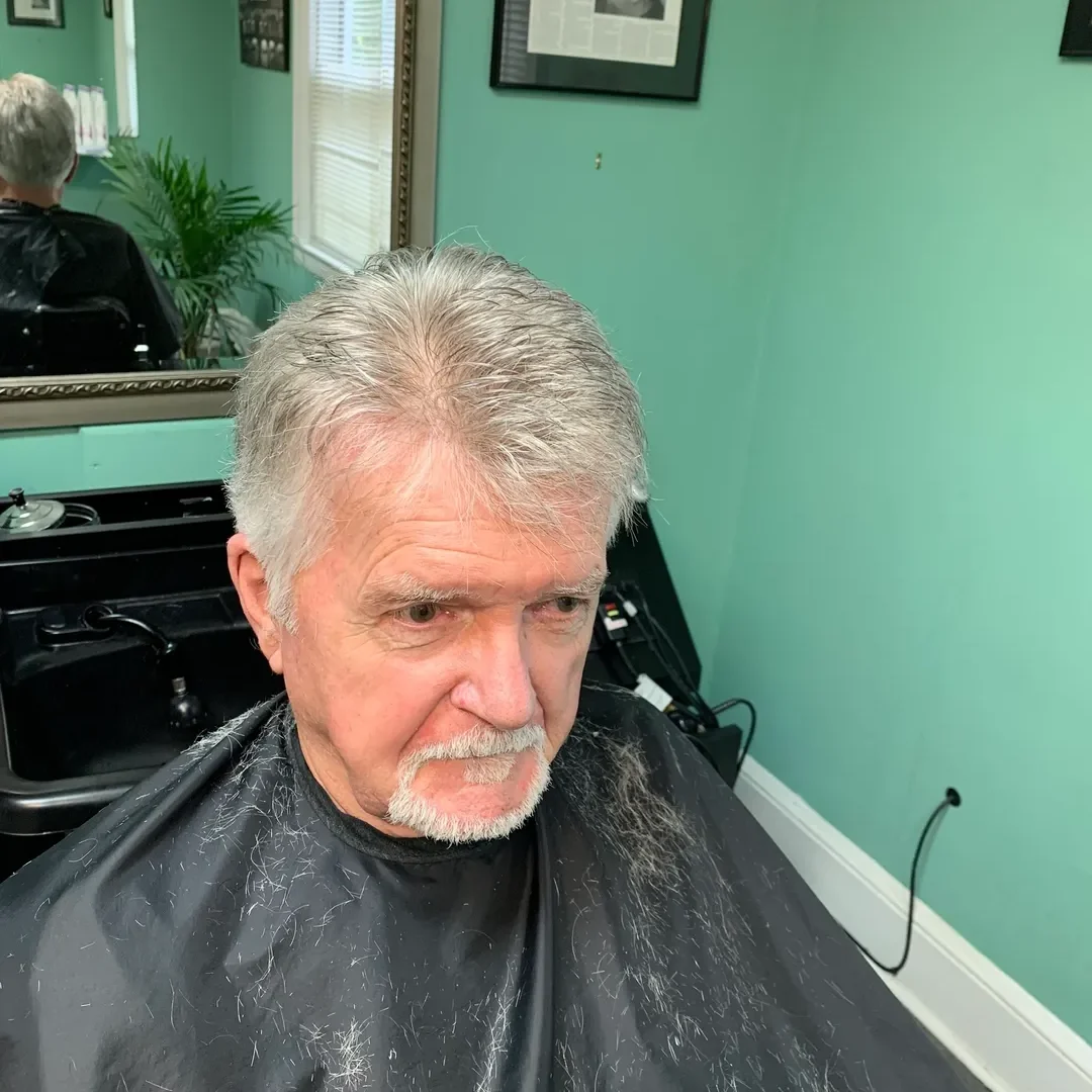 Man getting a haircut in barber shop.
